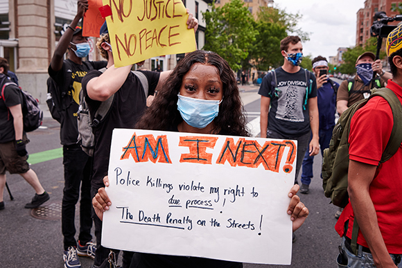 Black woman holds "Am I Next" poster at George Floyd protest (photo credit: Geoff Livingston) 