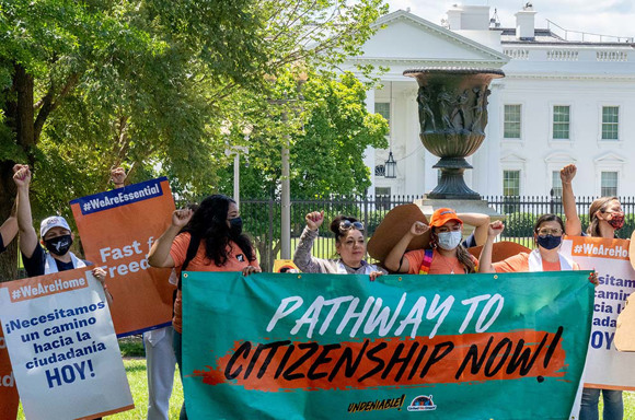 Activists outside The White House hold signs demanding a pathway to citizenship