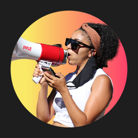 A woman holds a megaphone chanting at a protest.