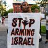 Protestor holding sign "Stop arming Israel"