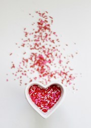 heart dish with candy sprinkles in it and around it
