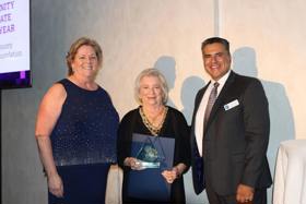 Bonnie Gilles and Leah Lacayo in formal event wear accepting VCCF's award at the Family Justice Center gala