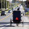 Amish buggy driving down a street